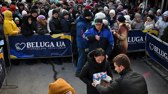 Saporischschja: Menschen erhalten Brot und Milch an einer humanitären Hilfsstation.
