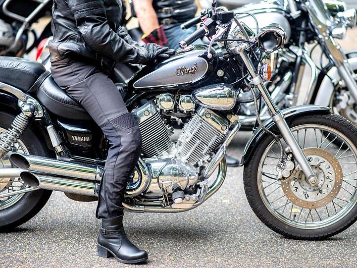 Eine Frau sitzt bei einer Demonstrationsfahrt auf ihrem Motorrad.