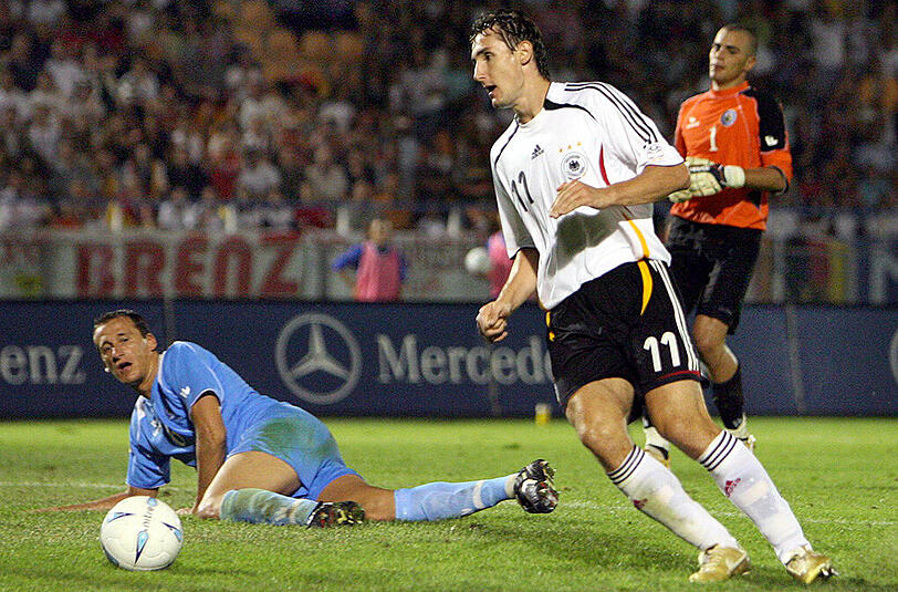 6. September 2006: Miroslav Klose umrundet auf dem Weg zum 6:0 San Marinos Torwart Aldo Simoncini (rechts) und Alessandro da Valle (links). Das 13:0 in jenem WM-Qualifikationsspiel ist das Rekordergebnis einer DFB-Elf auf fremdem Platz.