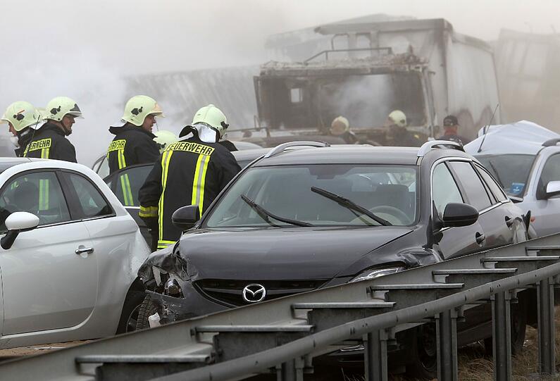 Feuerwehrleute sind am Freitag auf der Autobahn A19 bei Kavelstorf in der Nähe von Rostock bei einer Massenkarambolage im Einsatz. Bei einem Sandsturm fuhren in beiden Fahrtrichtungen Dutzende Fahrzeuge und LKW ineinander und brannten teilweise aus.