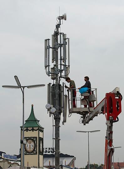Techniker bauen am Montag auf der Theresienwiese in Muenchen waehrend der Aufbauarbeiten fuer das Oktoberfest 2012 zusaetzliche Mobilfunkmasten auf, damit der Handy- und UMTS-Empfang waehrend der Wiesn fuer die erwarteten Besuchermassen ausreicht.
