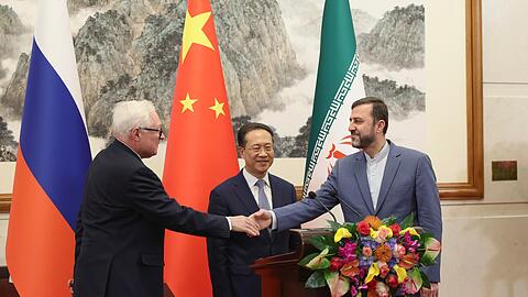 Russlands Vizeaußenminister Rjabkow gibt bei einem Treffen dem iranischen Vizeaußenminister Kazem Gharibabadi die Hand. (im Hintergrund Chinas Vizeaußenminister Ma Zhaoxu - Archivbild)