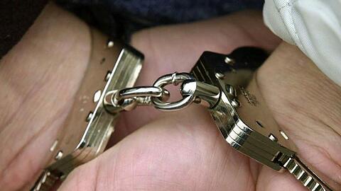 Ein Mann in Handschellen.