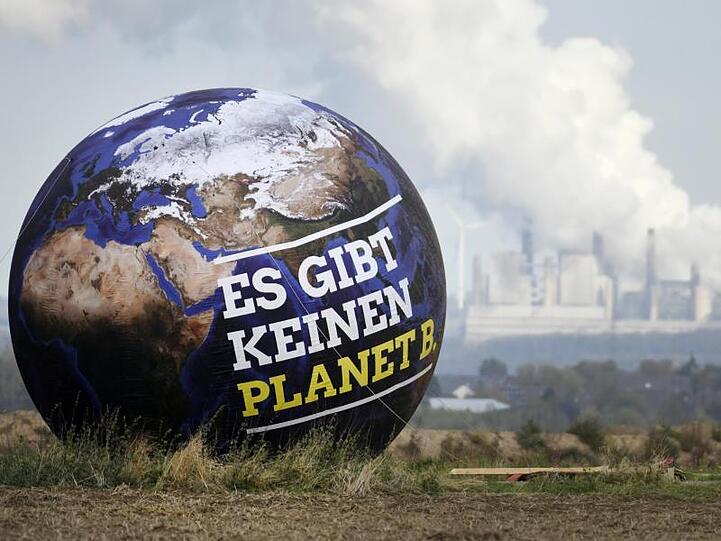 Ein Ballon mit der Aufschrift "Es gibt keinen Planet B." ist vor Braunkohlekraftwerken zu sehen. Foto: Ina Fassbender/Archivbild