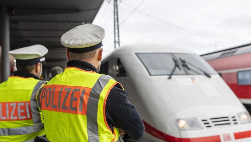 Zwei Beamte der Bundespolizei beobachten einen ICE. Foto: Patrick Seeger/dpa
