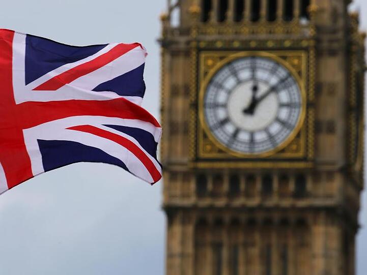 Die britische Nationalflagge, der Union Jack, weht vor dem Uhrturm Big Ben.