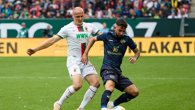 Der Augsburger Sven Michel (l) und der Mainzer Marco Richter kämpfen um den Ball.