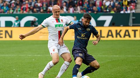 Der Augsburger Sven Michel (l) und der Mainzer Marco Richter kämpfen um den Ball.