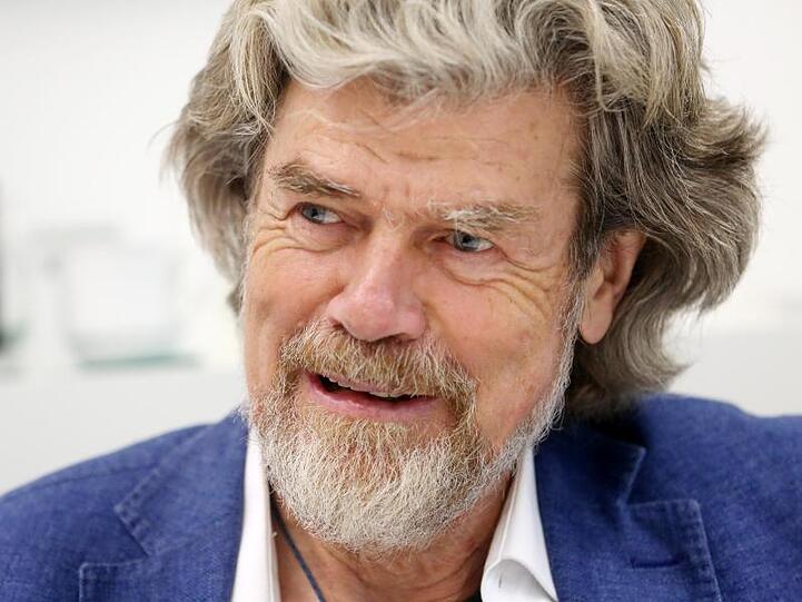 Der Südtiroler Bergsteiger Reinhold Messner lächelt, während er Fragen eines Journalisten beantwortet. Foto: Roland Weihrauch/dpa/Archivbild