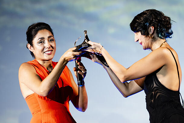 Die  französisch-iranische Schauspielerin Golshifteh Farahani (l.) von ihrer Kollegin Zar Amir Ebrahimi erhält den "Excellence Award Davide Campari" beim 78. Internationalen Filmfestival von Locarno auf der Bühne der Piazza Grande.