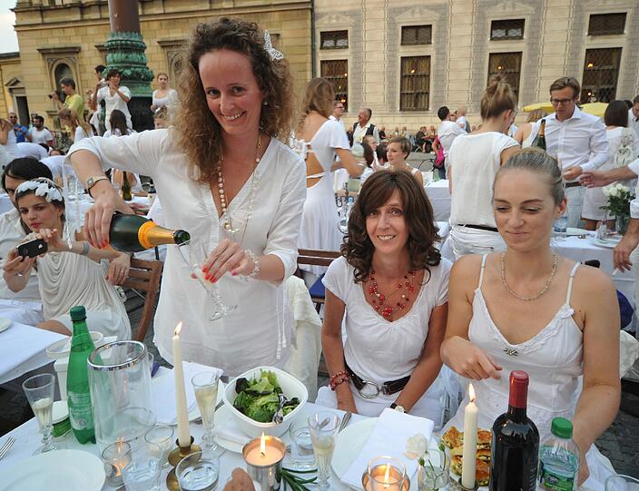 Feiner Flashmob: Rund 500 weiß gekleidete Menschen haben sich am Donnerstagabend am Münchner Odeonsplatz spontan zu einem Abendessen unter freiem Himmel getroffen - Sehen Sie hier die besten Bilder...
