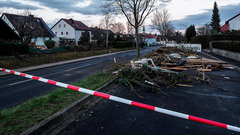 Zusammengetragener Schutt liegt bei Morgendämmerung in Kürnach (Bayern) auf einer abgesperrten Nebenstraße. Eine Windhose, auch als Tornado bezeichnet, hatte am Vortag erhebliche Schäden in der unterfränkischen Ortschaft angerichtet. Zahlreiche Häuser und Lauben waren durch den Sturm zu Schaden gekommen. Verletzt wurde niemand.