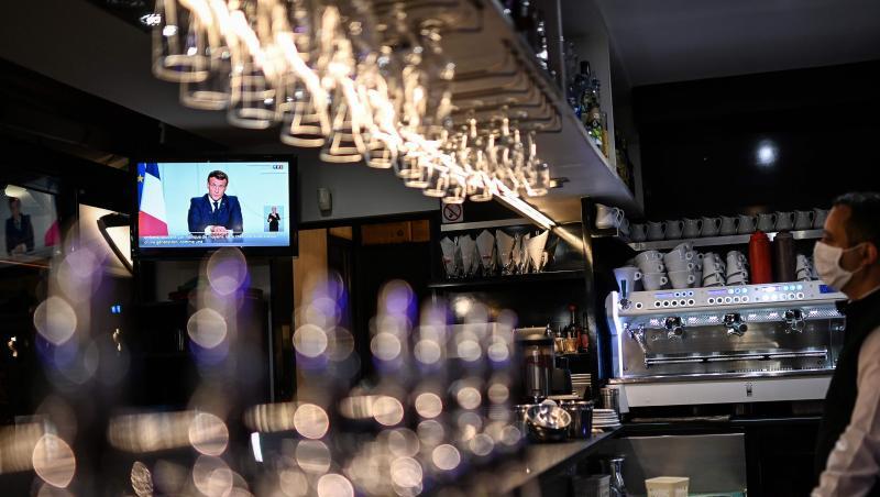 Ein Barkeeper schaut sich die Fernsehansprache von Präsident Macron in einem Café in Marseille an.