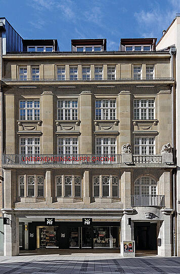 Weinstraße 4 (Frontansicht nach Renovierung): Das dreigeschossige, neuklassizistische Altstadthaus wurde 1908/09 nach Plänen von Max Neumann errichtet. Es besitzt eine aufwendig mit Lisenen gegliederte Natursteinfassade.