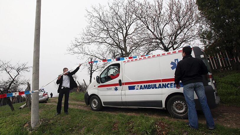 Ein Krankenwagen fährt in das abgeriegelte Dorf Velika Ivanca, wo der Täter 13 Verwandte erschossen und seine Frau und sich selbst schwer verletzt hat. Ein Krankenwagen fährt in das abgeriegelte Dorf Velika Ivanca, wo der Täter 13 Verwandte erschossen und seine Frau und sich selbst schwer verletzt hat.