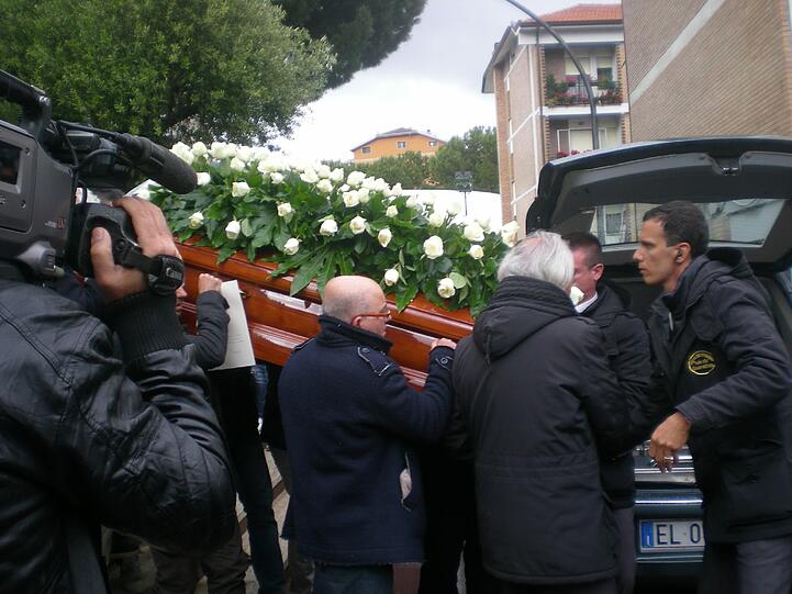 Der Sarg ist mit weißen Rosen geschmückt.
