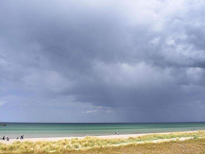 Dunkle Wolken ziehen an der Ostsee bei Prerow über das Meer.