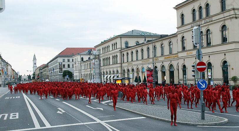 Star-Fotograf Spencer Tunick lässt zur Eröffnung der Opernfestspiele für seine Installation hunderte bunt angemalte Menschen durch München laufen. Das Highlight: Die rot-goldenen Teilnehmer stellen sich an Münchner Monumenten entlang der Ludwigstraße auf. Hier gibts die Bilder!