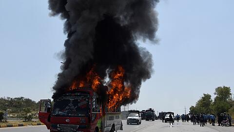 Rauch steigt aus einem brennenden Bus während Zusammenstößen von Anhängern des ehemaligen pakistanischen Premierministers Khan und der Polizei.
