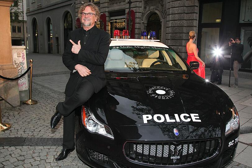 Filmproduzent Martin Krug hängt lässig auf der Motorhaube des Deko-Polizeiautos ab und beteuert: "Ich bin zu hundert Prozent Single."