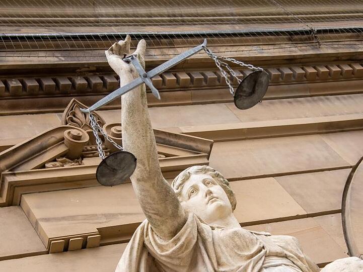 Vor dem Landgericht hält eine Statue der Justitia eine Waagschale. Foto: Stefan Puchner/dpa/Symbolbild