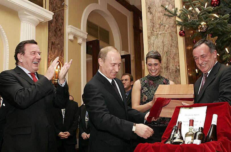 Schröder und Putin beguchtachten am Rande der deutsch-russischen Konsultationen in Hamburg 2004 deutsche Weinspezialitäten.
