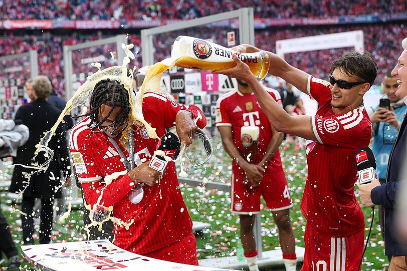 Selbst beim Live-Interview hat man keine Ruhe: Michael Olise kassiert eine Bierdusche von Tom Bischof.