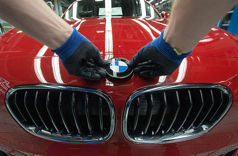 Ein BMW-Emblem wird im Werk in Regensburg auf einen BMW der 1er Reihe geklebt.