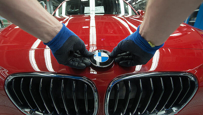 Ein BMW-Emblem wird im Werk in Regensburg auf einen BMW der 1er Reihe geklebt. Ein BMW-Emblem wird im Werk in Regensburg auf einen BMW der 1er Reihe geklebt.