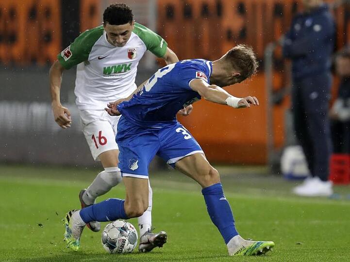 Ruben Vargas (l) von Augsburg und Stefan Posch von Hoffenheim in Aktion. Foto: Michael Probst/AP/POOL/dpa