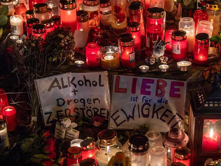 Kerzen, Blumen, Stofftiere und zwei Zettel mit den Aufschriften sind an der Fürstenrieder Straße aufgestellt. Foto: Lino Mirgeler/dpa