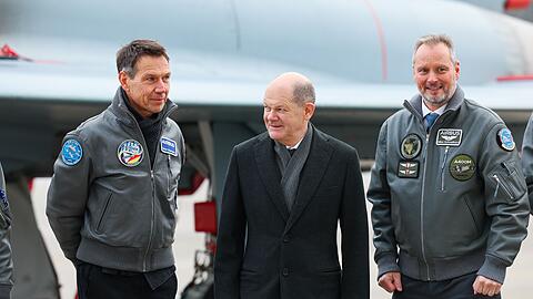 Bundeskanzler Olaf Scholz (SPD, M) besucht den Airbus-Militärstandort und steht mit Rene Obermann (l), Verwaltungsratsvorsitzende der Airbus SE und Mike Schöllhorn (r), CEO der Airbus Defence and Space.