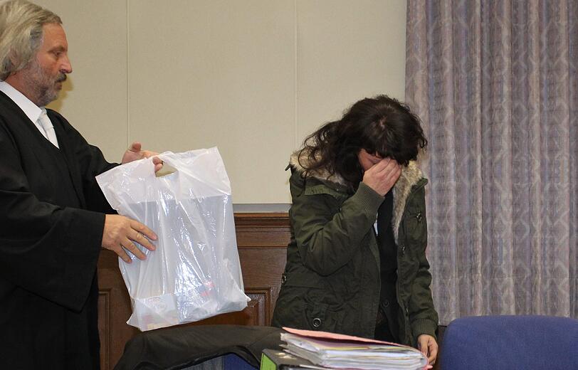 Die Angeklagte beim Prozess-Auftakt im Landgericht Schweinfurt. Hinter der weißen Plastiktüte wird sie sich während der Verlesung der Anklage verstecken.