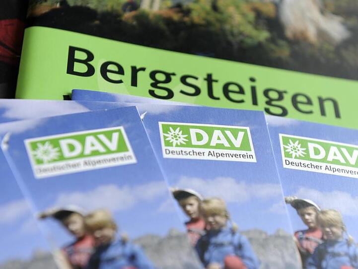 Prospekte mit dem Logo des Deutschen Alpenvereins (DAV) liegen auf einem Tisch. Foto: picture alliance / dpa/Illustration