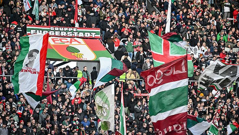 Fans des FC Augsburg schwenken ihre Fahnen in der WWK-Arena. (Archivfoto) Fans des FC Augsburg schwenken ihre Fahnen in der WWK-Arena. (Archivfoto)