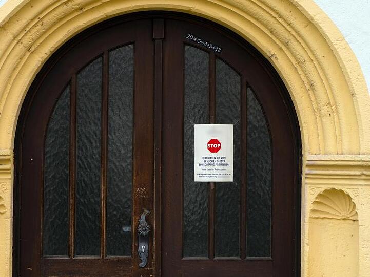An einer Tür zu einem Würzburger Seniorenheim ist ein Schild angebracht, das von Besuchen abrät. Foto: Nicolas Armer/dpa/Archivbild