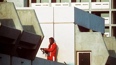 Das Archivbild vom 05.09.1972 zeigt einen bewaffneten Polizeibeamten im Trainingsanzug, der den Block im Olympischen Dorf in München abschirmt. Karl Heinz Hohensinn war Einsatzleiter bei der erfolglosen Befreiung der Geiseln. 	Foto: Horst Ossinger/dpa
