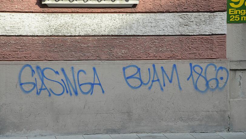 Blau auf Grau: „Giasinga Buam“. Der Name eines Fanclubs. Blau auf Grau: „Giasinga Buam“. Der Name eines Fanclubs.