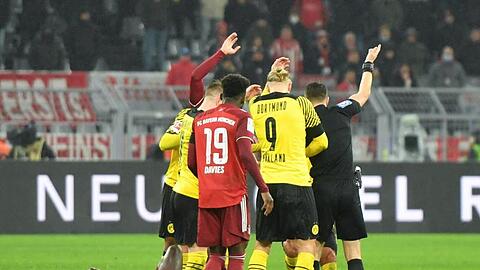 Dortmunds Julian Brandt und Münchens Dayot Upamecano liegen verletzt auf dem Boden.
