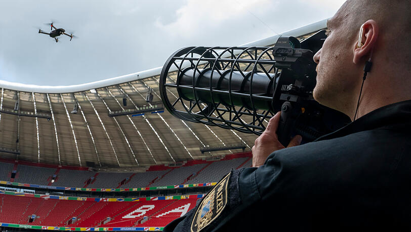 Ein speziell ausgebildeter Polizist zeigt w&auml;hrend der Vorstellung des M&uuml;nchner Sicherheitskonzepts zur Fu&szlig;ball-Europameisterschaft 2024 in der Allianz Arena eine kontrollierte Landung einer Drohne mithilfe eines Jammers.