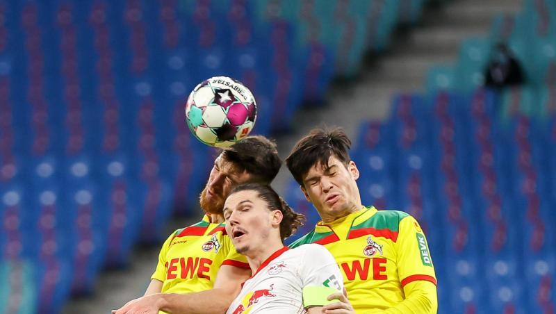 Leipzigs Marcel Sabitzer (M) im Kopfballduell mit den Kölnern Jorge Mere (l) und Salih Özcan.