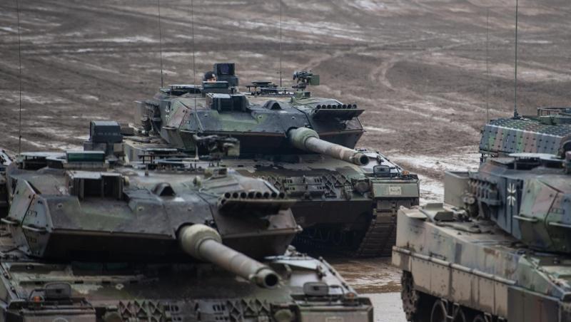 Drei Kampfpanzer der Bundeswehr vom Typ Leopard 2A6 und ein Schützenpanzer vom Typ Puma stehen bei einer Übung im Gelände. (Archivbild).