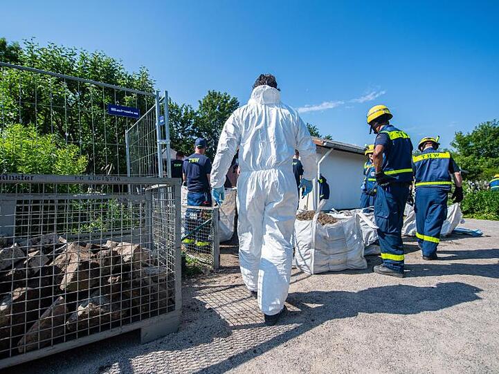Mitarbeiter vom Technischen Hilfswerk (THW) tragen vor dem Abriss der Gartenlaube des Verdächtigen im Missbrauchsfall von Münster einen steinumrandeten Erdhügel ab.