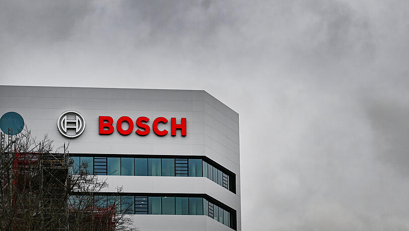 Das Logo des Technologiekonzerns Bosch an der Zentrale. Der Konzern muss mehr Stellen kürzen als gedacht.