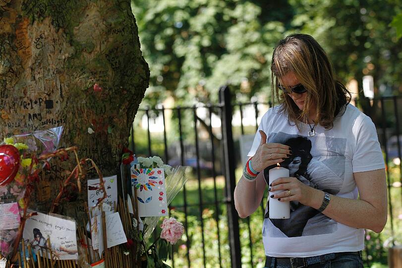 Die britische Souldiva Winehouse prägte in den
vergangenen Jahren wie kaum eine andere Sängerin die Musikszene.
Doch ihr musikalischer Erfolg wurde immer wieder von ihren Alkohol-
und Drogeneskapaden überschattet. Hier stellt ein weiblicher Fan eine Kerze vor dem Haus der Sängerin ab.