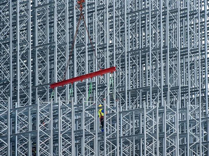Arbeiter errichten das innere Gerüst eines Lagerhauses. Die deutsche Industrie erhält wieder mehr Aufträge.