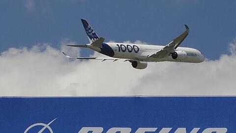 Ein Airbus vom Typ A350 - 1000 hebt bei einer Messe in Paris über einem Boeing-Schriftzug ab.