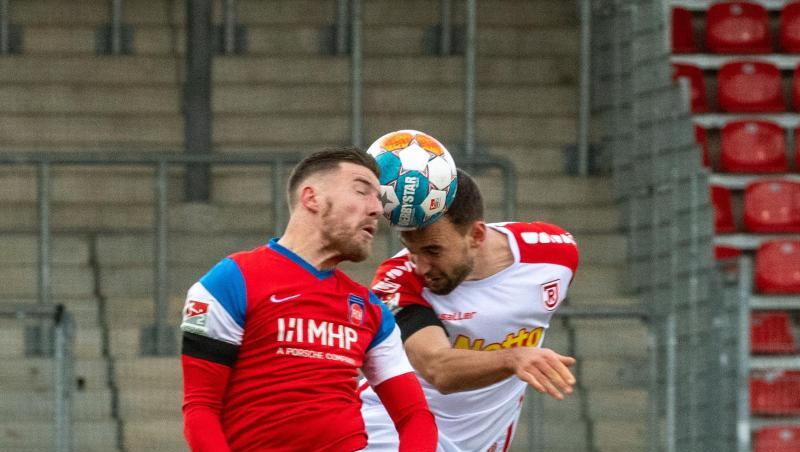 Heidenheims Christian Kühlwetter (l) und Regensburgs Benedikt Gimber sind im Kopfballduell.