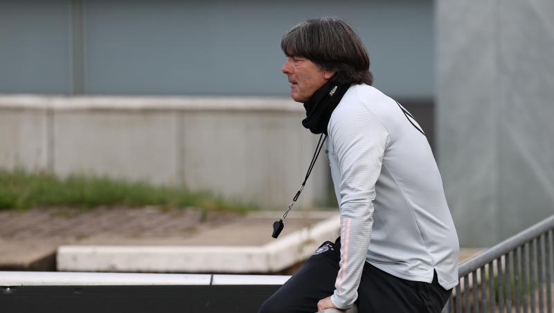 Joachim Löw klettert beim DFB-Training über eine Absperrung.