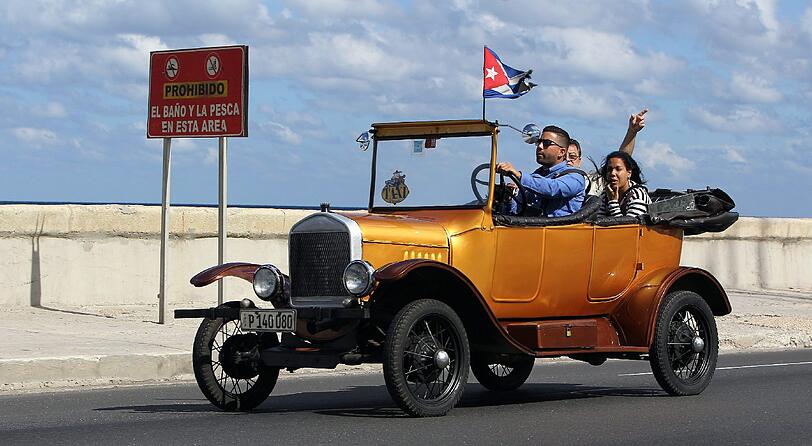Ein Olditmer mit kubanischer Flagge fährt am Donnerstag durch Havanna.
